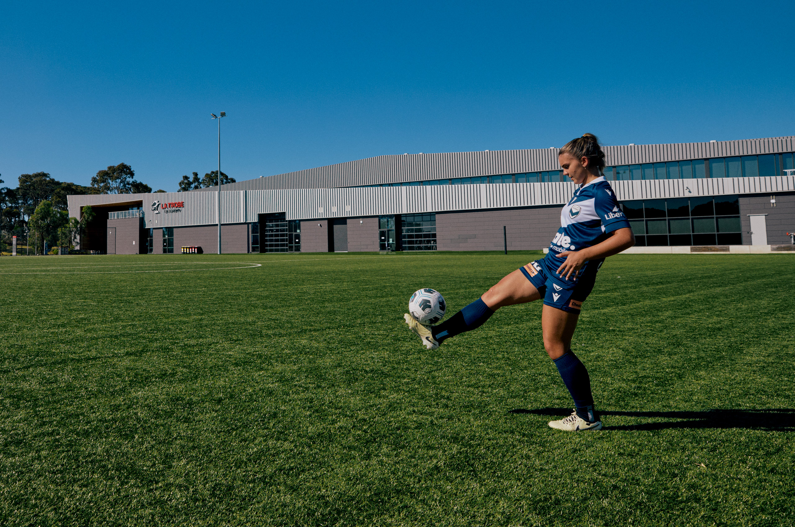 Student playing soccer in field