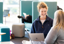 Female student talking to mentor with computer in front of them