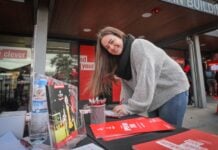 Student at orientation event filling out a form at an information booth