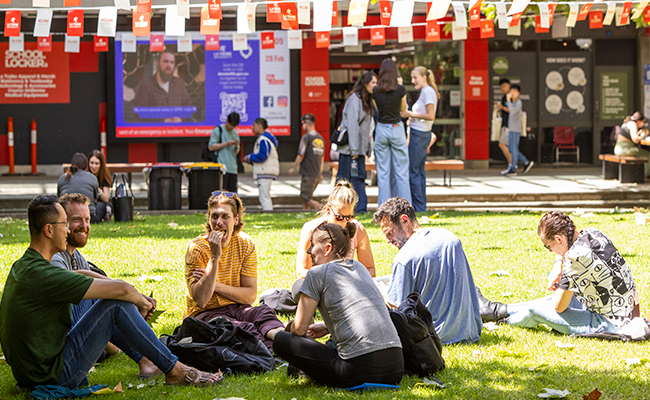 Students sitting on the lawn in the Agora